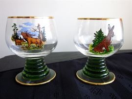 Two small German footed snifters with gold trim and woodland scenes.