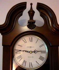 Howard Miller "Malia" quartz pendulum wall clock.  Solid wood, cherry finish, pediment top.  Westminster chime - #625466.  26-1/4" tall, 12-1/4" wide, 5-1/2" deep.