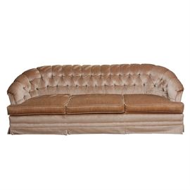 Vintage Velvet Sofa: A vintage velvet sofa. The sofa features a curved back that forms the arms at the sides. There are three box seat cushions with piped edges. The upholstered sofa back features channels and button tufted details and is fully upholstered in a light toast colored velveteen fabric. No maker’s marks.