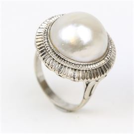 18K White Gold and Cultured Mabe Pearl Cocktail Ring: An 18K white gold cocktail ring featuring one center cultured mabe pearl mounted in a bezel setting with a reeded border.