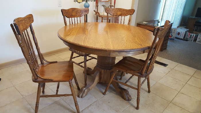 Round oak table with leaves and four chairs - $225