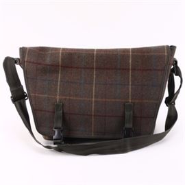 J. Crew Messenger Bag: A J. Crew messenger bag. This gray plaid crossbody bag has a flap closure with buckles on black straps attached on top of the flap, and features a zippered exterior pocket under the flap as well as a zippered interior side pocket. A tag on the interior reads “J. Crew”.
