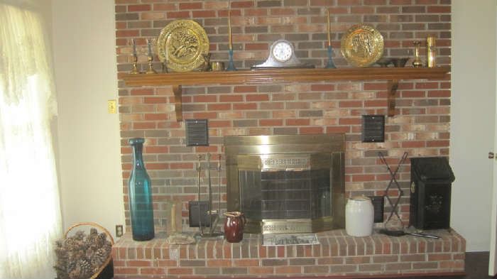 Vintage decorations on fireplace include large colored bottle with stopper, fireplace set, large metal tongs for wood, antique coal scuttle hod  bucket, mantle clock