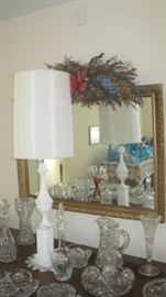 Tall lamp on table with cut glass and other glassware, large wall mirror with gold gilt frame 