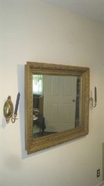 Wall mirror in gold gilt frame with brass sconces on each side