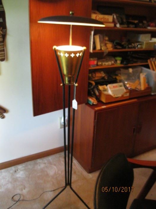 Mid Century floor lamp with disc shade over brass pierced light receptacle supported on three iron rods continuing to feet.