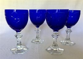 $40. Set of four crystal goblets with cut cobalt globes and clear stems. Two of the bases have very small nicks. Each glass measures approximately 7.25"H x 3"dia.