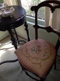 One of two antique needlepoint chairs; antique table