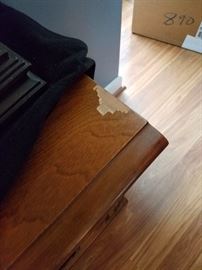 Veneer repair needed on wood cabinet.