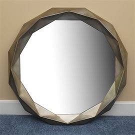 Wall Mirror With Faceted Style Frame: A wall mirror with a faceted style frame. This selection features a round mirror set in a metallic mirror with a faceted motif. It is labeled by the manufacturer to the reverse.