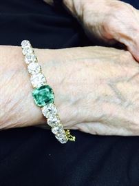 Antique diamond and emerald bracelet. Set with twelve old mine cut diamonds weighing approx 6 carats total. Set in the center is a natural emerald of approx 2.25 carats. Unmarked yellow gold.