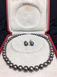 Mikimoto black Tahitian pearls. 12.1mm to 8.1mm. 16 inch with matching earrings. White gold and diamonds.