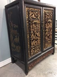 Antique Chinese cabinet detail. Carved and gilt doors with painted side panels.