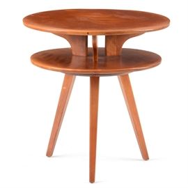 Cushman Mahogany Side Table: A Cushman mahogany side table. This table has a two-tiered, circular construction and rests on tapered, splayed legs. It is marked to the bottom with a metal tag which reads, “A Genuine Cushman Colonial Creation”.