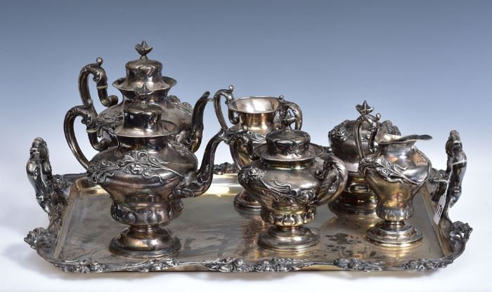 Art Nouveau Silver Plated Tea Set 	
consisting of tray, 23" long, two teapots,
creamer, sugar, catch pot and covered 
butter dish with presentation inscription to 
Joseph Bremel, 1908 (NY politician)