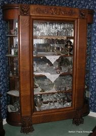 Late 19th Century Quarter Sawn Oak Display Cabinet, serpentine sides, Griffin Heads at the top, Lion Claw feet. Magnificent piece, standing 73 inches, width 57 inches and depth 16 inches.