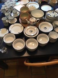 Table full of Dansk plates, bowls, cups and more