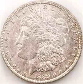 1889 Morgan Silver Dollar: An 1889 Morgan silver dollar. Designer: George T. Morgan. Mintage: 21,726,000. Metal Content: 90% silver, 10% copper. Diameter: 38.1 mm. Weight: 26.73 grams. Very good condition.