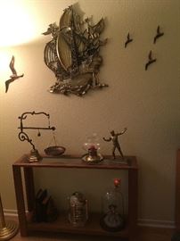 shelf with brass scale and wall sculptures