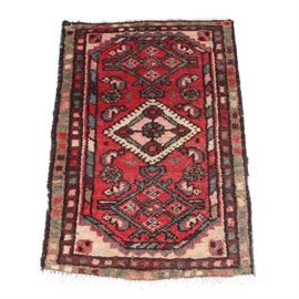 Antique Hand-Knotted Persian Hamadan Accent Rug: An antique hand-knotted Persian Hamadan accent rug. This small accent rug features a central diamond shaped medallion in green, brick red and sand hues upon a floral and diamond patterned brick red field. The rug has a geometric patterned compound border complete with natural warp fringe at either end. The rug is unmarked.