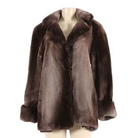 Sheared Beaver Fur Jacket: A contemporary style sheared beaver fur jacket. This jacket features cuffed convertible sleeves, powdery soft pelts, two outer pockets, and two hook and eye closures.