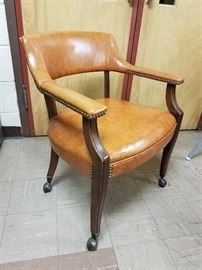Naugahyde chair with nailhead trim and casters. Rolls easily. 
