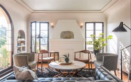 Our first suite of furniture, including walnut chairs, Mouille floor lamps, travertine table 