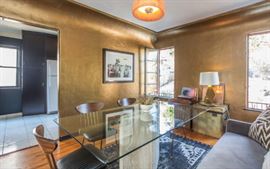 Stunning glass and travertine dining table, bistro couch, midcentury dining chairs