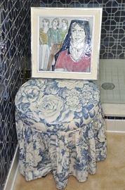 Upholstered vanity stool shown with artwork by Salsan.