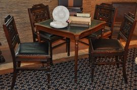 Vintage leather top game table shown with four Eastlake chairs.