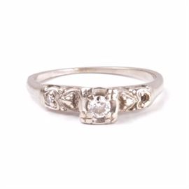 Late Edwardian 14K White Gold and Diamond Ring: A late Edwardian 14K white gold and diamond ring with a center diamond and heart-detailed shoulders with side diamond. The ring has a total diamond weight of 0.115 ctw.