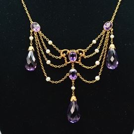 14K Yellow Gold Amethyst and Pearl Chandelier Style Necklace: A 14K yellow gold amethyst and pearl chandelier style necklace. This necklace features briolette amethyst drops among pearl studded chains with oval amethyst accents.