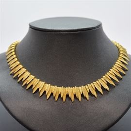 18K Yellow Gold Leaf Design Necklace: An 18K yellow gold leaf design necklace. This embossed leaf necklace features sliding links in a graduated three leaf design.