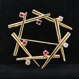 14K Yellow Gold Ruby and Diamond Brooch: A 14K yellow gold ruby and diamond brooch by Danfrere. This chop-stick wreath design features ruby and diamond accents.