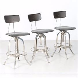 Swivel Bar Stools: A selection of swivel bar stools. Featuring black composite seats and backs, these three bar stools include chromed frames and adjustable height. They are marked to the underside “Made in India.”