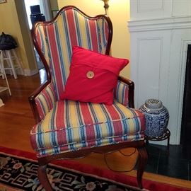 Comfy wing-back chair.  Asian blue & white pot on cast metal stand setting beside the chair