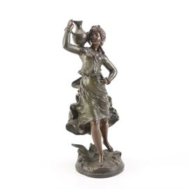 Spelter Sculpture of Girl With a Jug: A spelter reproduction statue of a girl with a jug. This bronze tone piece depicts a girl in a flowing dress carrying a jug on her shoulder. The metal base includes a foundry seal reading, “Fabrication Francaise Paris Made in France”.