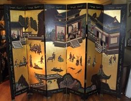 Stunning Vintage Asian-Style Room Divider
6 brass hinged panels. Each panel is 6'tall x 16"wide. Gorgeous and detailed front features scene depicting many people doing various activities in and outside of beautiful dwellings. Backside is more subtlely decorated with bamboo and birds lakeside scene on black. Overall good condition with some visible signs of wear that's common with age. Some spots, light chips, etc.