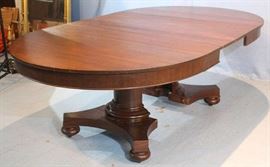 041b  Mahogany Empire dining table with column base, bun feet and 4 leaves with 2 skirted, 2 not skirted, 29 in. T, 88 in. L, 52 in. W.