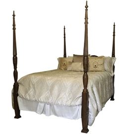 Four Post Queen Rice Bed: A four poster rice bed. The queen size bed features pediment headboard and footboard, fluted and carved posts with rice sheaves and acorn finials. The piece is made of wood that is stained in a rich cherry color. The bedding is included.
