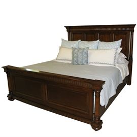 Thomasville "Fredericksburg" King Size Panel Bed Frame with Linens: A king size bed frame by Thomasville with included linens. The panel bed frame was made by Thomasville and is part of their “Fredericksburg” collection. The bed features a mantle-like headboard and footboard trimmed with detailed molding and turned posts. The piece is made of wood and is stained a rich “whiskey” finish. The included linens features a sheet set, duvet, quilt and throw pillows in hues of white and turquoise.