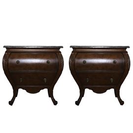 French Style Side Tables: A Bombe-form marble top nightstand. The front apron is curvilinear with two small cabriole legs. The piece features two drawers with bronze tone hardware and detailed carving along each side.