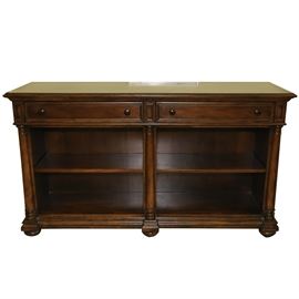 Thomasville Entertainment Stand: A Thomasville furniture entertainment stand. The stand is made of wood that has been stained a rich cherry color. The piece features two drawers to the top with circular pulls and dovetail joinery. The stand has three columns and shelves in the lower portion for storage. It is marked Thomasville to the inside left of the drawer.