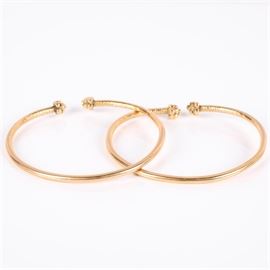 14K Yellow Gold Bangle Bracelets: A pair of 14K yellow gold cuff bangle bracelets with hand engraved designs.