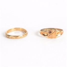 10K Yellow Gold Rings: A pair of 10K yellow gold rings. The pair includes a band ring with hearts, and a Joseph Esposito-designed signet-style ring with a small red stone.
