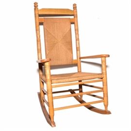 Rocking Chair with Woven Rush Back and Seat: A rocking chair with a woven rush seat and back. The chair features round turned wood side rails, and legs, with flat arm rests. The back rest and seat feature woven rush material. No maker’s marks.