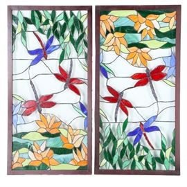 Dragonfly Stained Glass Windows: A pair of stained glass windows. The windows both contain panes of glass fixed in place to form designs of lotus flowers and dragonflies in yellow, blue, red, and darker colors, and both are in a frame.