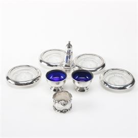 Sterling With Weighted Sterling Tableware Featuring Towle Silversmiths: A group of sterling tableware. This includes four sterling rimmed glass coasters. There are two matching FTG salt cellars with cobalt blue liners, a Towle Silversmiths napkin ring, and an Empire weighted sterling salt shaker with gadroon trim. The total approximate weight of napkin ring with shaker cap is 1.155 ozt.