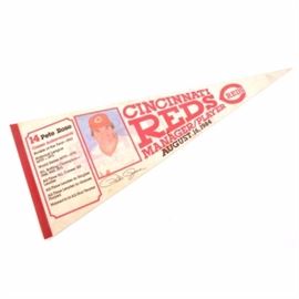 Pete Rose Picture Manager Pennant: A Pete Rose picture pennant. The pennant has printed graphics and a picture of Pete Rose. A section to the left of Pete’s picture has a small list of his baseball accomplishments; to the right of Pete’s picture it says, “Cincinnati Reds Manager/Player August 16, 1984” with the Reds logo.