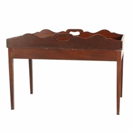 Mid 20th Century Mahogany Tray Table: A mid 20th century tray style coffee table made in mahogany with scroll cut design to the long sides of the top with cut-out handles and dovetailed joinery. The top is attached to the base with screwed construction. Unmarked.